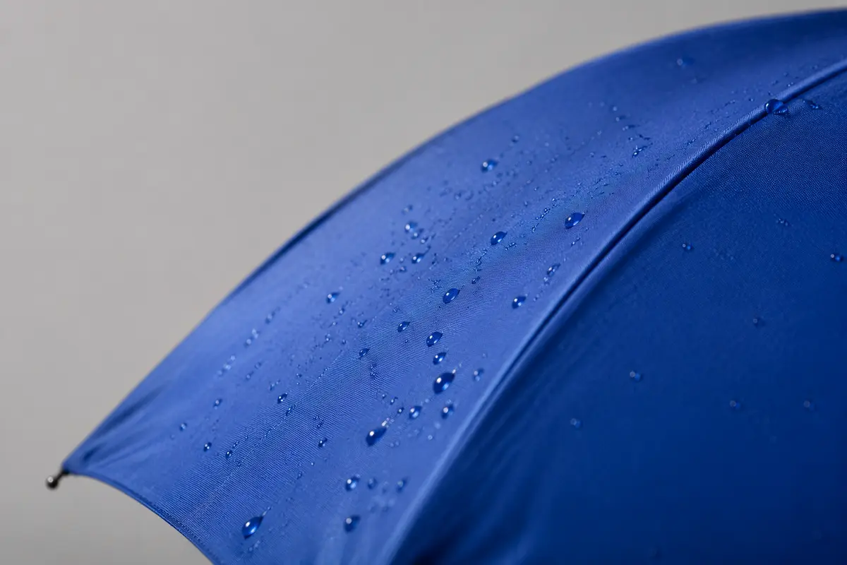 Close-up comparison image of blue nylon umbrella canopy fabric with water droplets