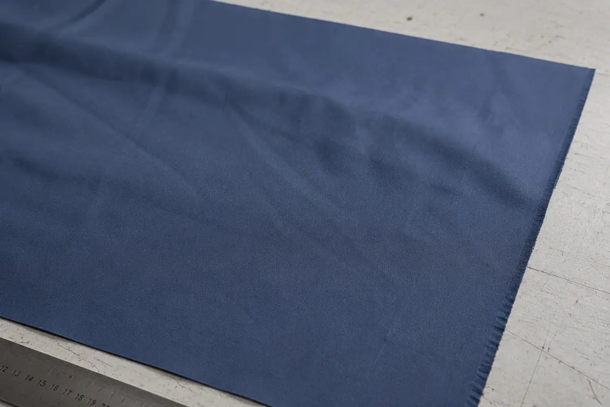 Close-up comparison image of slate blue standard polyester umbrella canopy fabric with water droplets