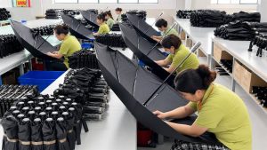 Umbrella sewing production workshop with workers assembling umbrellas