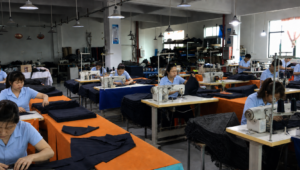 Uniformed workers joining custom umbrella canopy panels in a clean China umbrella factory