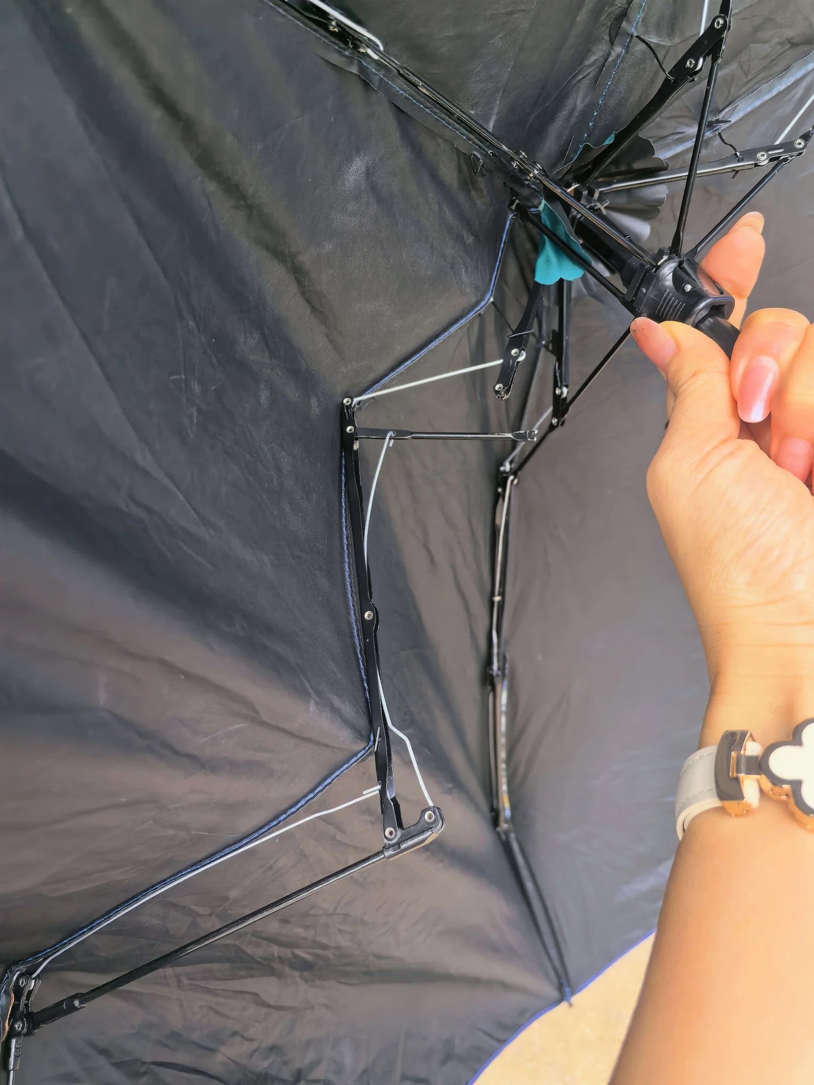 Close-up inspection of a broken umbrella rib and eyelet joint