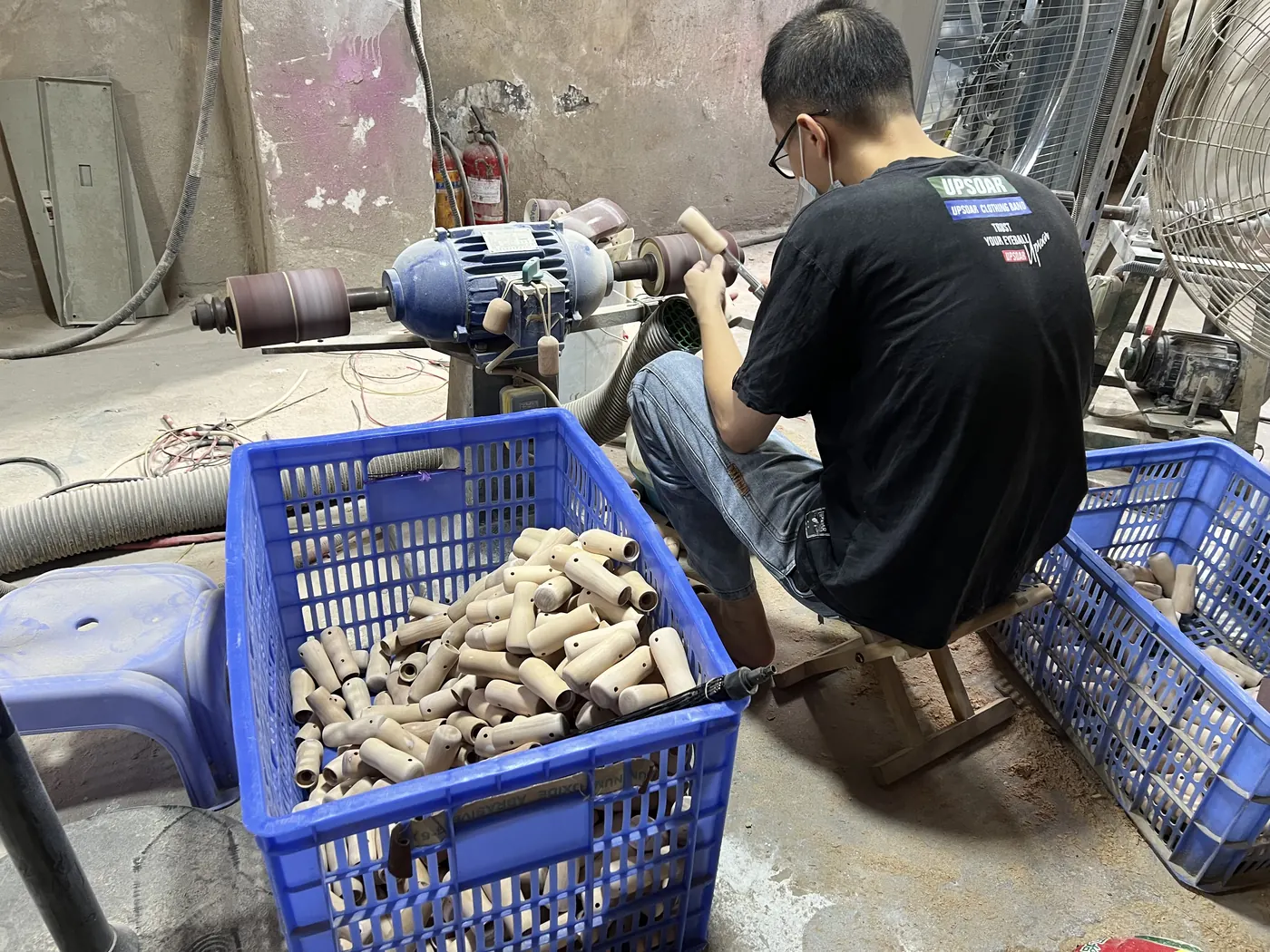 Worker sanding and finishing wooden handles for custom umbrellas