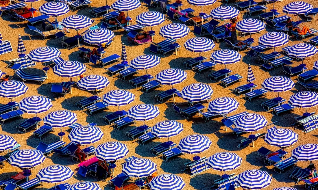 Blue and white striped beach umbrellas in an outdoor resort setting