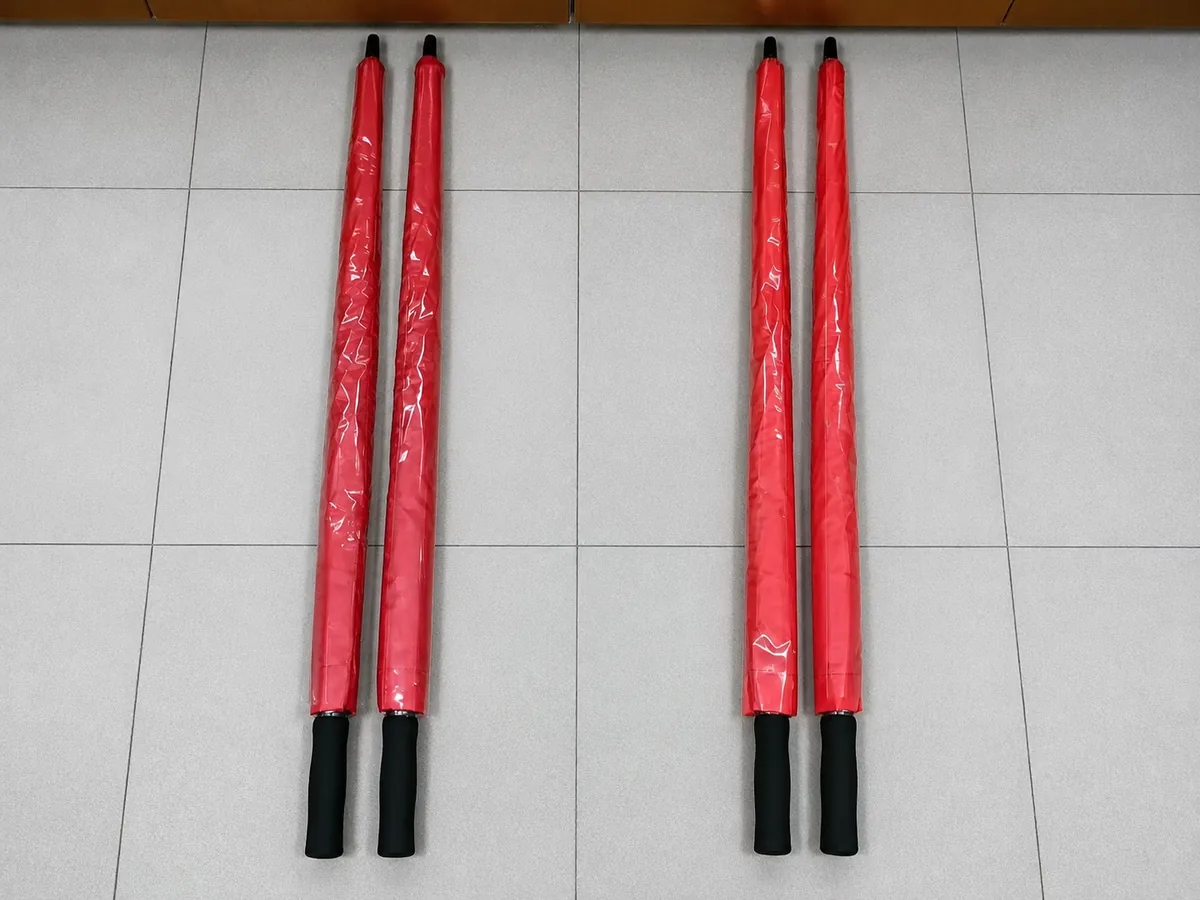 Four packed red custom golf umbrellas prepared for the Nigerian buyer's 50-piece trial inspection