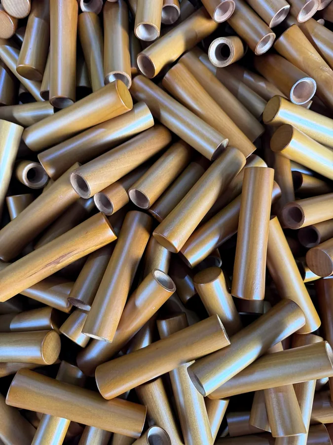 Processed wooden umbrella handle components showing drilled holes and surface finish